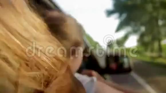 风吹过女孩的头发在车里日落视频的预览图