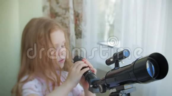 一个小女孩从她家的窗户透过望远镜看视频的预览图