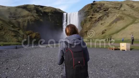 在冰岛拍摄Seljalandsfoss瀑布的女人视频的预览图