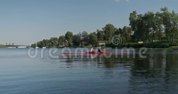 年轻的运动队两个十几岁的男孩带着双艇皮艇在水面上视频的预览图