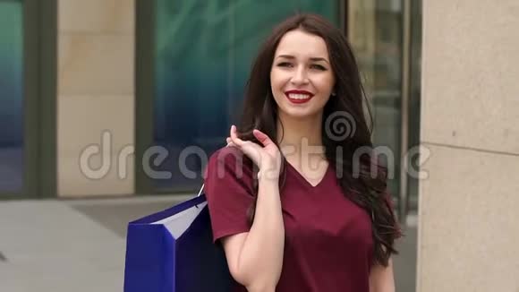 年轻女子带着购物袋在城市里散步视频的预览图