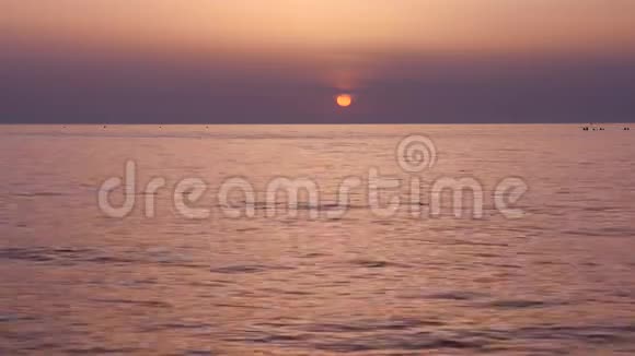 海滩上美丽的日落海浪缓缓翻滚视频的预览图