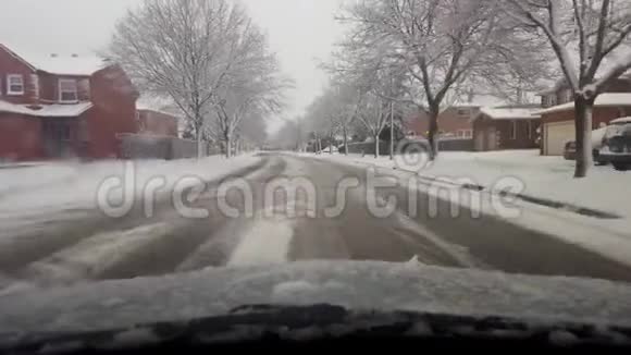白天开车穿过白雪皑皑的冬季郊区司机视角POV雪化天气驾驶视频的预览图