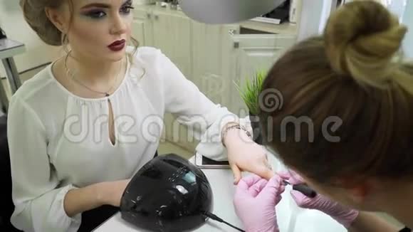 年轻女孩美甲师在美容院为一位美女做美甲视频的预览图