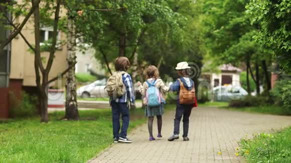 两个男孩和女孩放学后回家女孩掉了草帽男孩举起它学校朋友视频的预览图