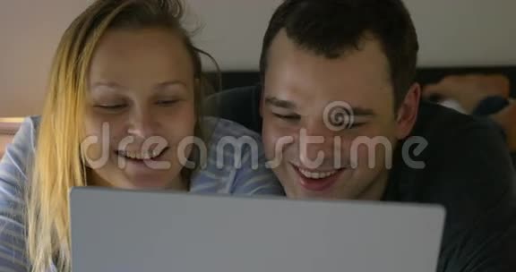 夫妻俩在笔记本上看幽默视频视频的预览图