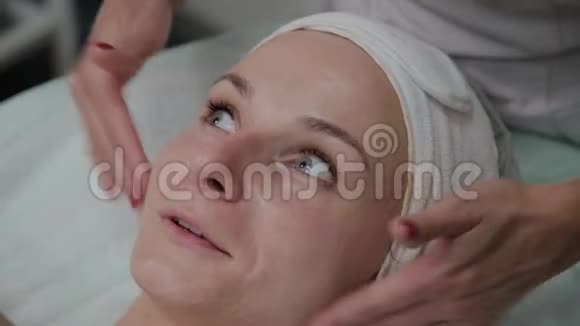 专业美容师给女孩脸上涂保湿霜视频的预览图