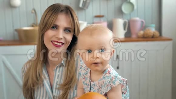 可爱的小孩画像幸福的爱心家庭妈妈在厨房里和宝宝玩耍带着白色微笑的妈妈视频的预览图