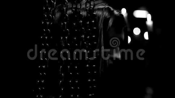 黑白黑暗背景神秘观手动近站在链帘后面的年轻美女视频的预览图