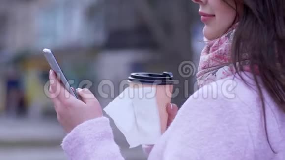 手机和咖啡在塑料杯里搂着女人特写视频的预览图