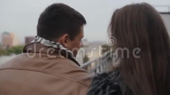 快乐的爱情一对黑发夫妇的后景走在屋顶上接吻关系和谐视频的预览图