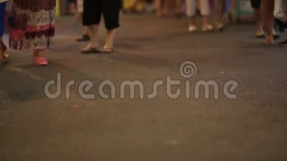 许多人脚穿过晚城的街道在晚上散步视频的预览图