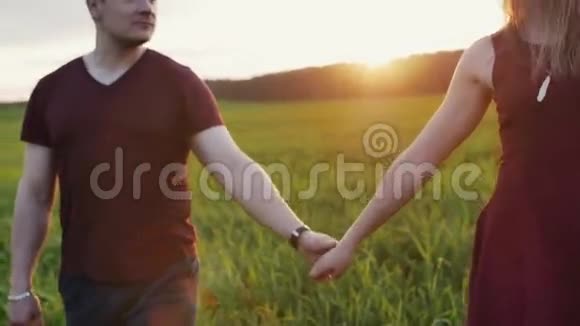 日落时分情侣在美丽的地方散步牵手恋人们温柔地拥抱女人戴眼镜慢莫稳定射击视频的预览图