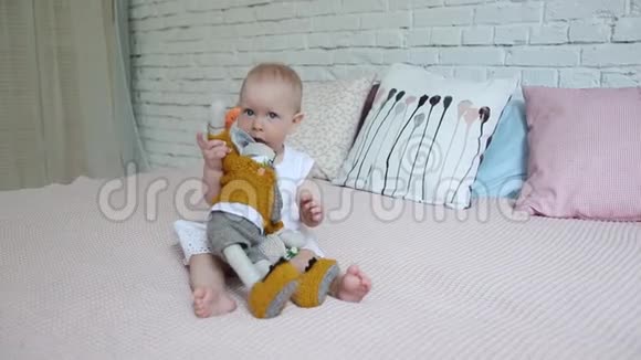 一个漂亮的小女孩正在床上玩一只柔软的玩具兔子视频的预览图