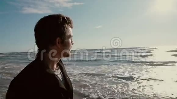 一张年轻男子的脸黑发和胡须谁正在享受美丽的海景视频的预览图
