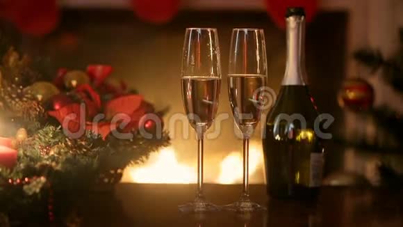 客厅的壁炉点燃了两杯香槟的圣诞餐桌视频的预览图