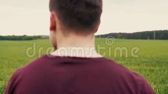 一个年轻的女人和她的爱人在一起很开心走在一片绿色的田野里牵着他的手慢莫稳定射击视频的预览图