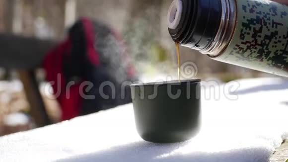 在下雪的冬天游客们停下来喝热水瓶里的茶视频的预览图