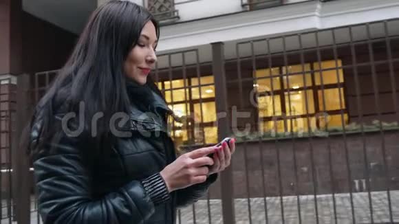 美女混血女用智能手机技术应用走在城市街道城市快乐视频的预览图