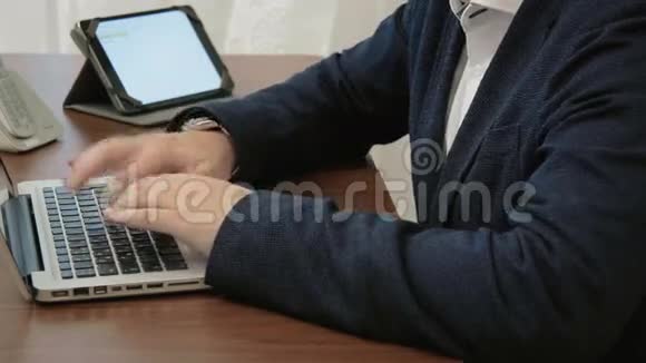 年轻疲惫的商人在他的办公室里手提电脑前工作看上去筋疲力尽视频的预览图