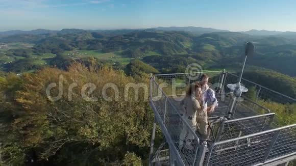 一对可爱的夫妇登上了一座了望塔在一片美丽的风景中视频的预览图
