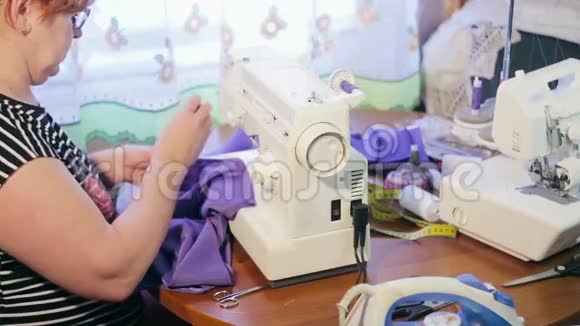 在缝纫机上工作的女人女人准备缝纫用的布料视频的预览图