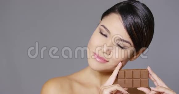 性感的年轻女人咬着巧克力棒视频的预览图