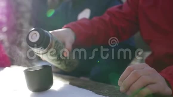 在下雪的冬天游客们停下来喝热水瓶里的茶视频的预览图