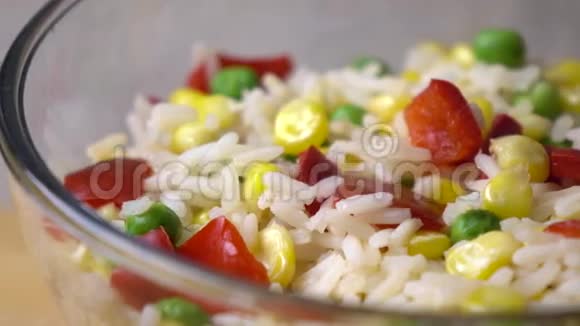 将米饭玉米豌豆和红甜椒混合在玻璃碗中4K小圆片视频的预览图