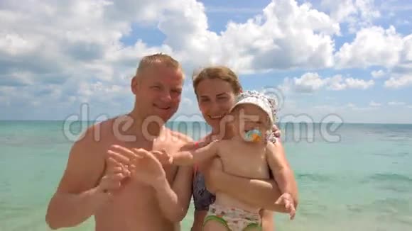 海滩上的幸福家庭挥手告别视频的预览图