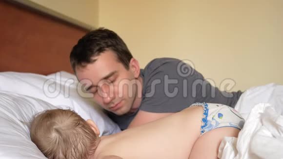 父亲亲吻睡在床上的儿子婴儿不到两岁视频的预览图