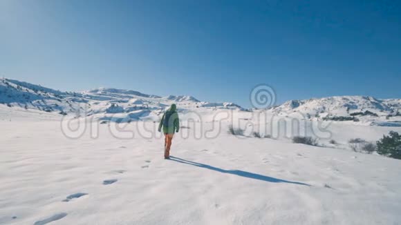 女孩在冬天的山上徒步旅行在冬天徒步旅行慢动作视频的预览图