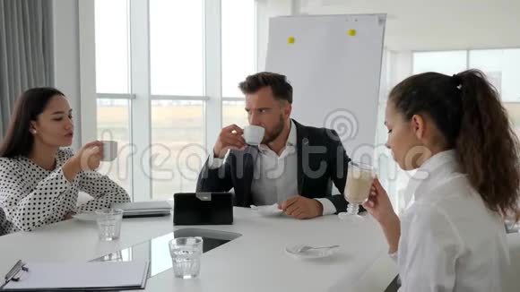 办公室休息商务人士在餐桌上喝咖啡办公室主任和员工休息创意团队视频的预览图