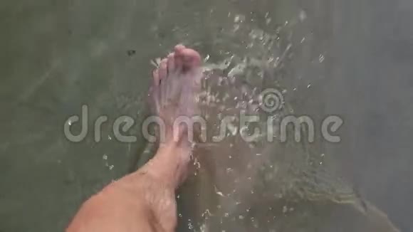 男子赤脚行走在沙滩上走进海水视频的预览图