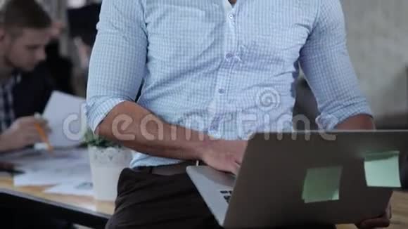 漂亮的成功混血老板坐在办公室里用笔记本电脑工作看着相机视频的预览图