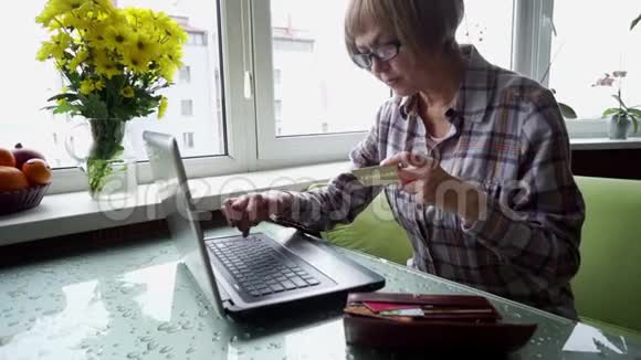 一位患有风湿性关节炎的老年妇女在家里使用网上银行视频的预览图