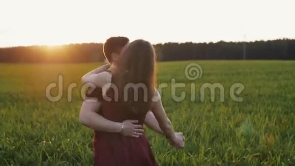 快乐美丽的恋人在大自然中玩得很开心夏天日落时男人和女人在田野里跳舞慢节奏视频的预览图