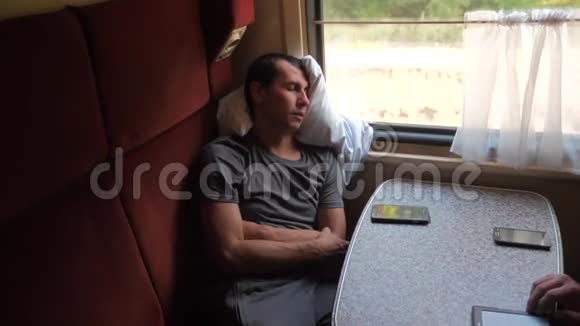 坐在客车里坐火车的人睡觉慢动作视频男人睡在火车上视频的预览图