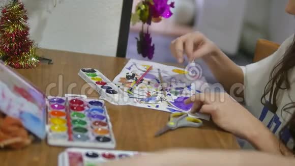 女孩们用颜料在桌子上画房子孩子们在室内画画视频的预览图