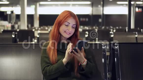 年轻女性在机场候机楼使用电话视频的预览图