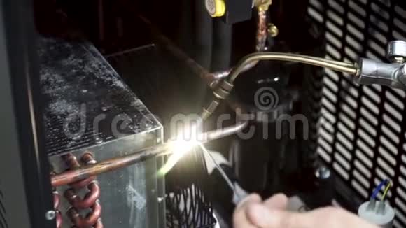 一名工人正在用煤气炉和焊料焊接铜管削减工人燃烧器加热细节金属视频的预览图