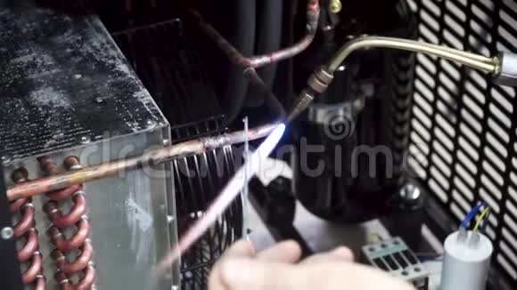 一名工人正在用煤气炉和焊料焊接铜管削减工人燃烧器加热细节金属视频的预览图