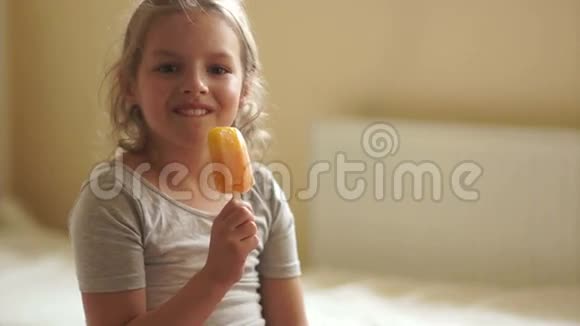 可爱的女孩吃冰淇淋并高兴地向观众展示视频的预览图