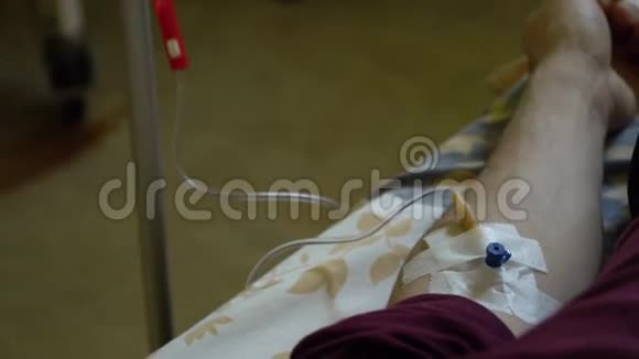 静脉注射通过静脉注射将药物注入静脉医院病房的一名男子躺在床上手视频的预览图
