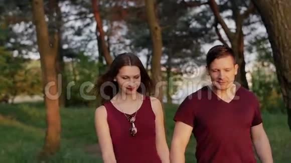 美丽的黑发夫妇走在大自然中微笑享受在一起的时光他们看起来既高兴又高兴慢莫稳定射击视频的预览图
