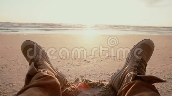 黎明时分两英尺高的棕色靴子在沙滩上休息视频的预览图