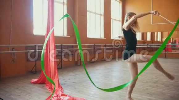 体操年轻女子用绿丝带慢动作训练体操视频的预览图