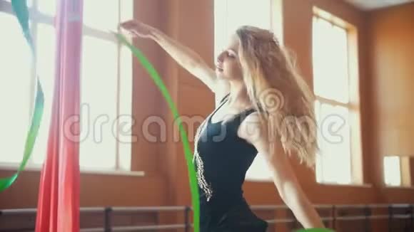 韵律体操年轻女子用绿色丝带训练体操动作动作缓慢视频的预览图