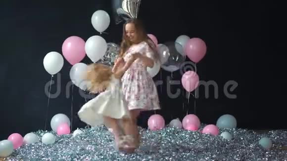 一对年轻的母亲和女儿玩得开心用五颜六色的氦气球摆姿势的肖像视频的预览图