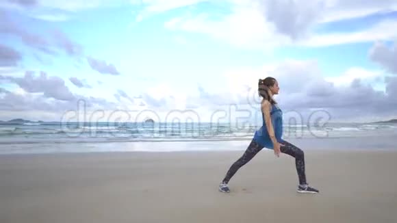 年轻女子在日出时在海边练习瑜伽晨练体操举起手来视频的预览图